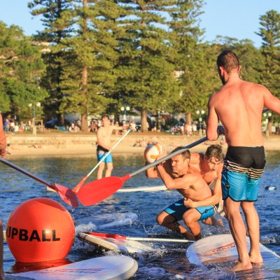Group of guys playing SUPBALL in the beach