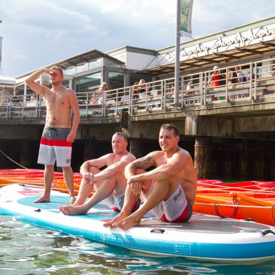 3 guys sitting on the SUP board