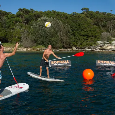 People playing SUPBALL on the beach