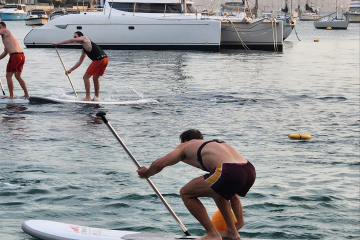 a group of people riding on the back of a boat in the water
